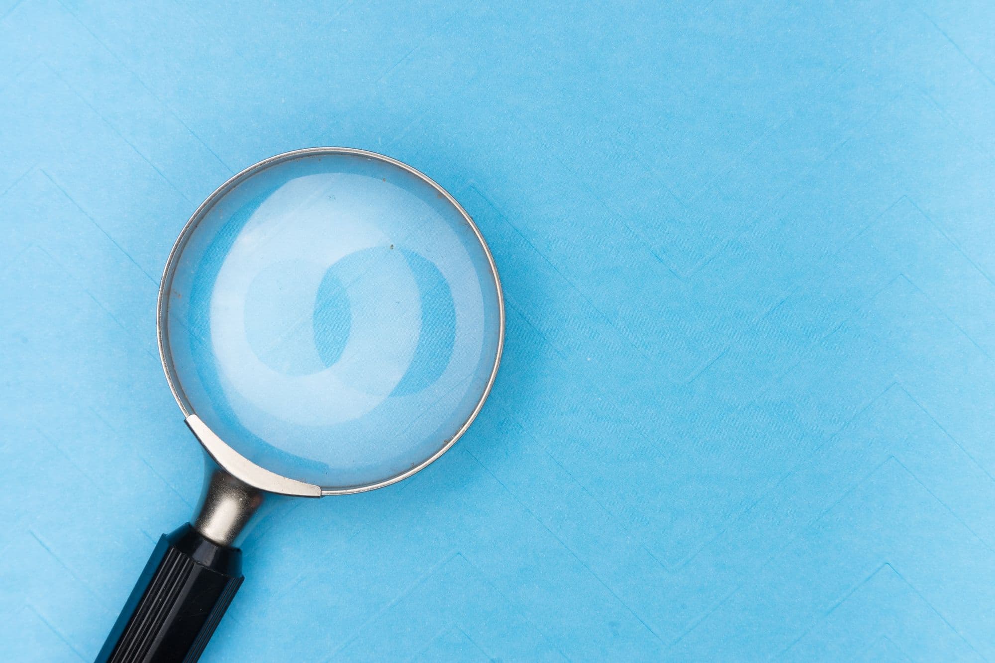 Magnifying glass against blue background
