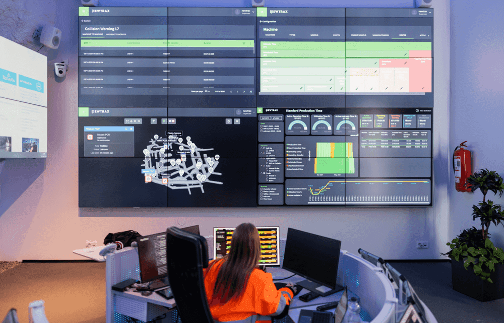 A worker looking at a large screen with the Newtrax dashboards